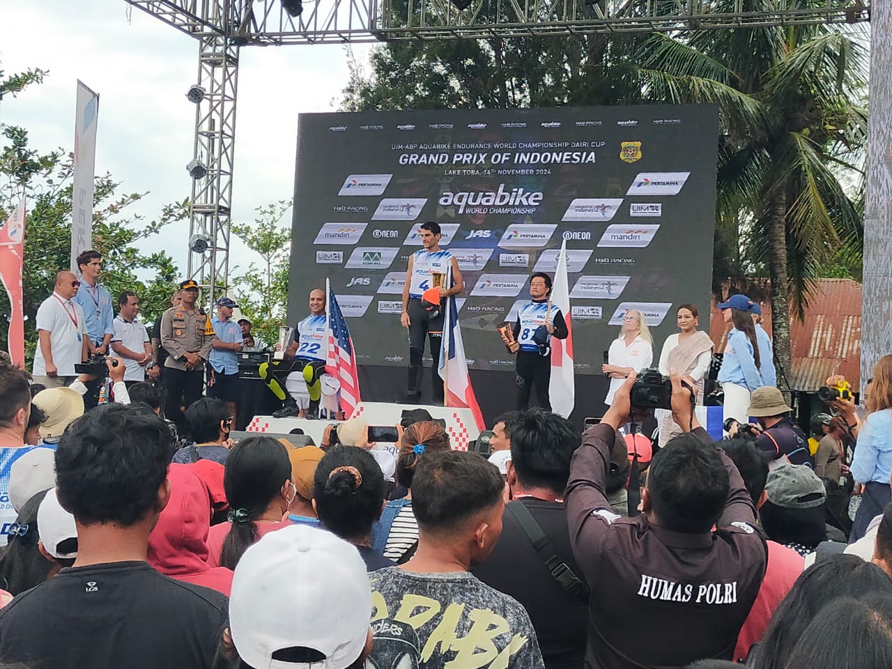 TERIMA TROPI: Pembalap asal  Prancis, Francois Medori bersama pembalap asal Amerika, Anthony Radetic dan pembalap asal Jepang, Isahai Hajime naik podium menerima tropi yang diserahkan Pj Bupati Dairi,
