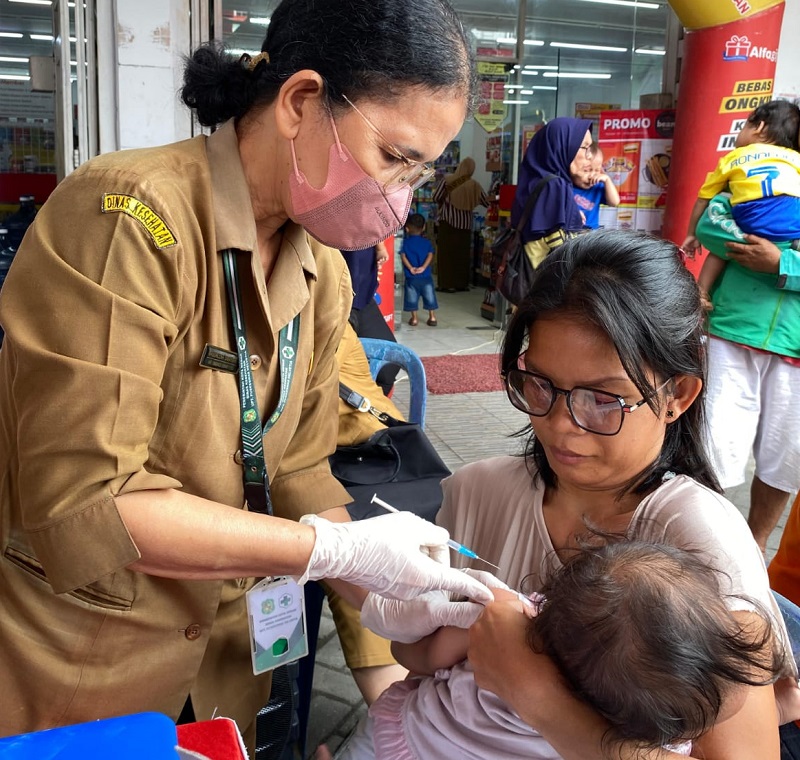CEK: Kader kesehatan saat sedang memeriksa bayi pada program