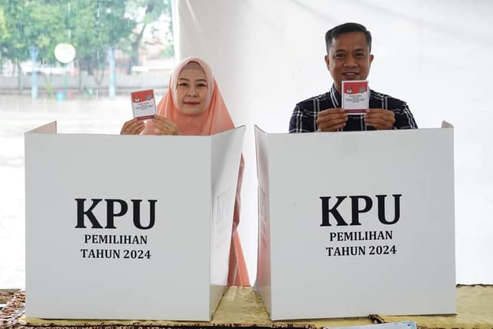 NYOBLOS: Pj Wali Kota Tebingtinggi Moettaqien Hasrimi didampingi istri, dr Dara Caprina nyoblosdi TPS 01 Kelurahan Rambung Kota Tebingtinggi. SOPIAN/SUMUT&nbsp;POS