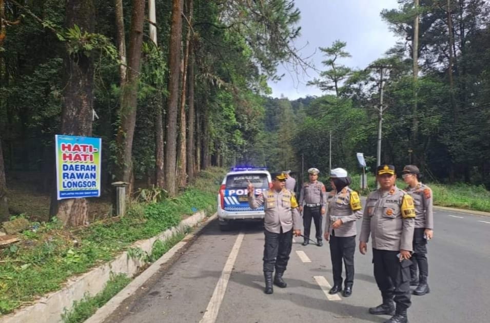 BANNER: Kapolres Karo memasang banner peringatan bahaya longsor di beberapa titik jalur Berastagi-Medan FOTO: SOLIDEO/SUMUT&nbsp;POS