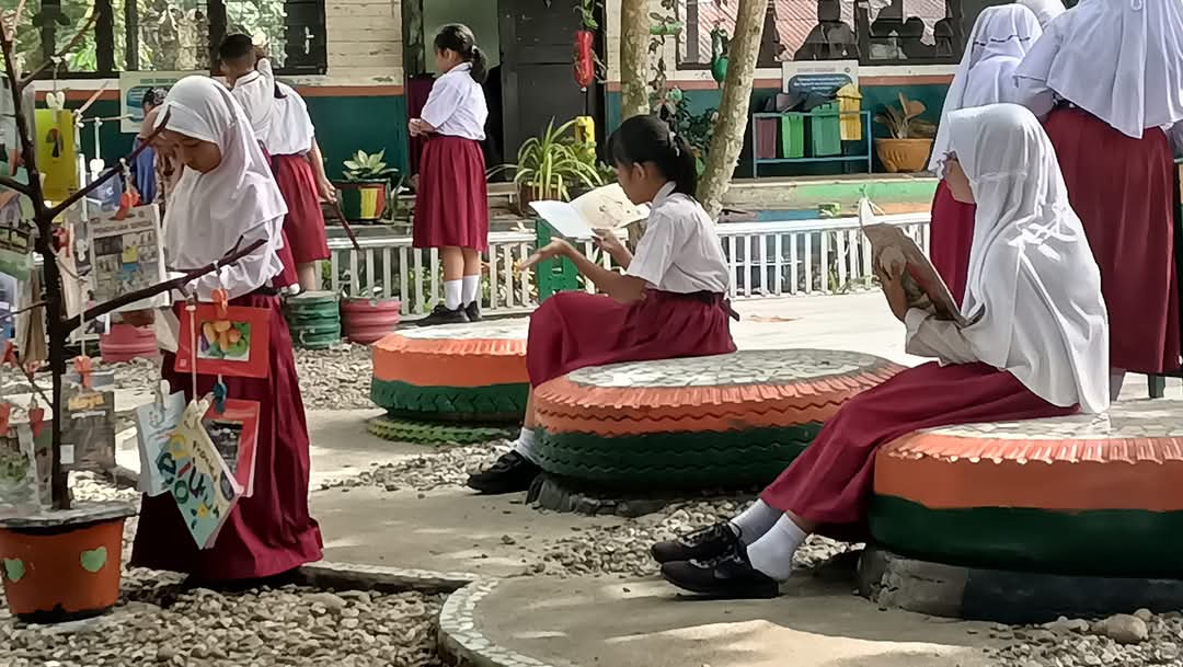 MEMBACA: Siswa SD Swasta RGM Blok Songo Labuhanbatu Selatan serius membaca di halaman sekolah yang tertata apik. (Dok SD&nbsp;RGM&nbsp;Blok&nbsp;Songo)