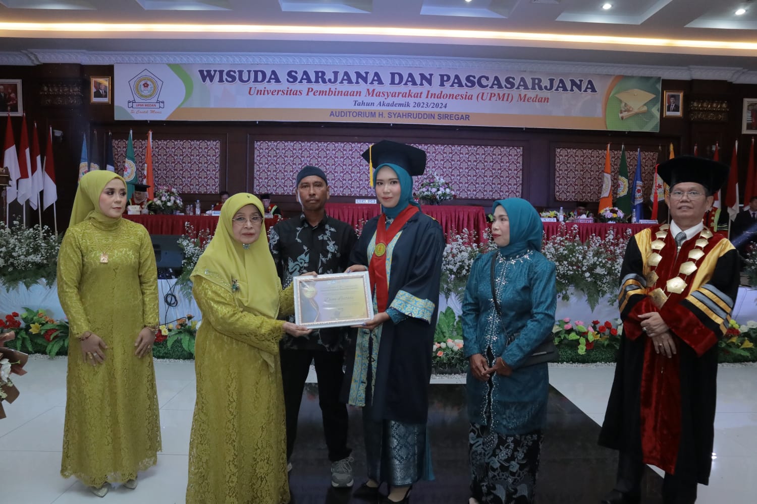 Ketua Yayasan UPMI Medan Dra Hj Nur&rsquo;aini Harahap menyerahkan piagam penghargaan kepada lulusan terbaik Dina Lestari&nbsp;dari&nbsp;FKIP.
