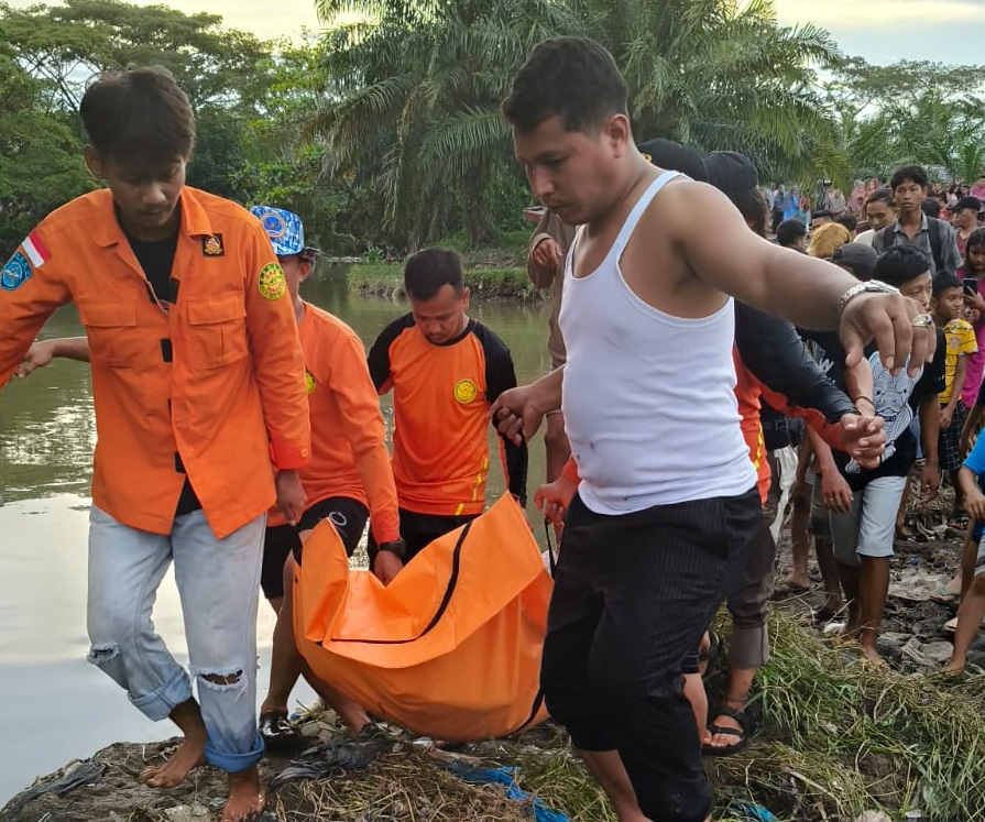 EVAKUASI: Petugas BPBD Kota Medan dan warga mengevakuasi jenazah korban hanyut dari sungai Bederah. ISTIMEWA/SUMUT&nbsp;POS