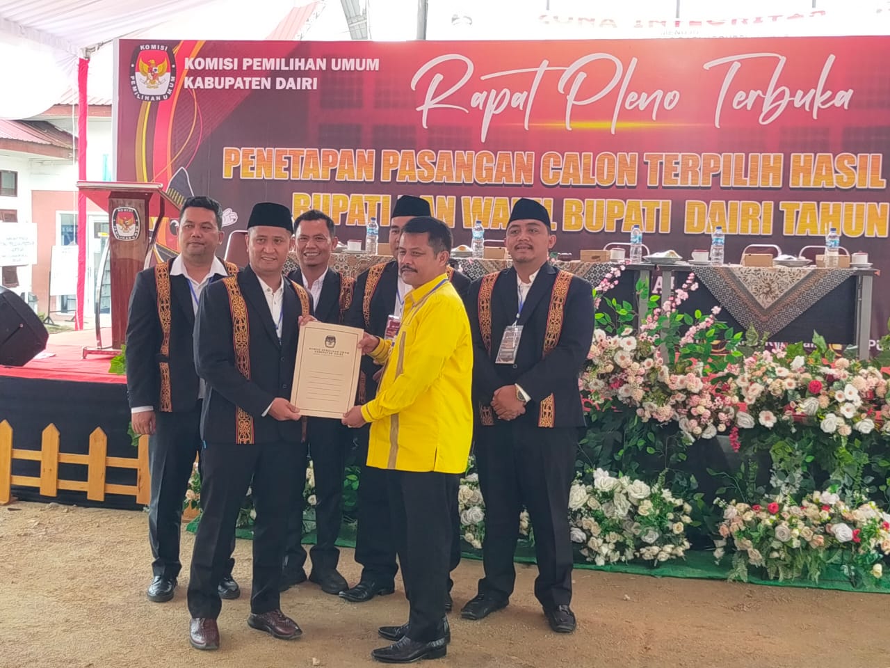 SERAHKAN. Ketua KPU Dairi, Ariyanto Tinendung menyerahkan salinan penetapan paslon Bupati/Wakil Bupati Dairi terpilih kepada tim pemenangan paslon nomor urut 5, Vickner Sinaga-Wahyu Daniel Sagala.