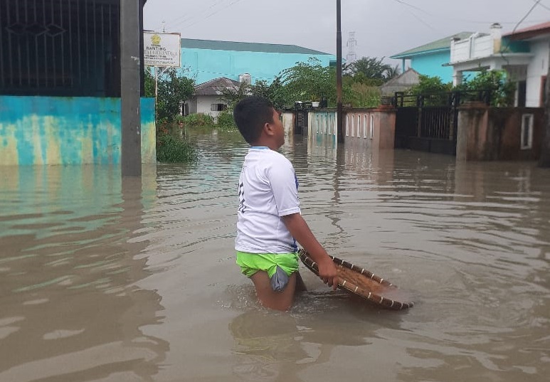 BERMAIN: Anak-anak bermain air di daerah pemukiman yang terkena&nbsp;banjir.