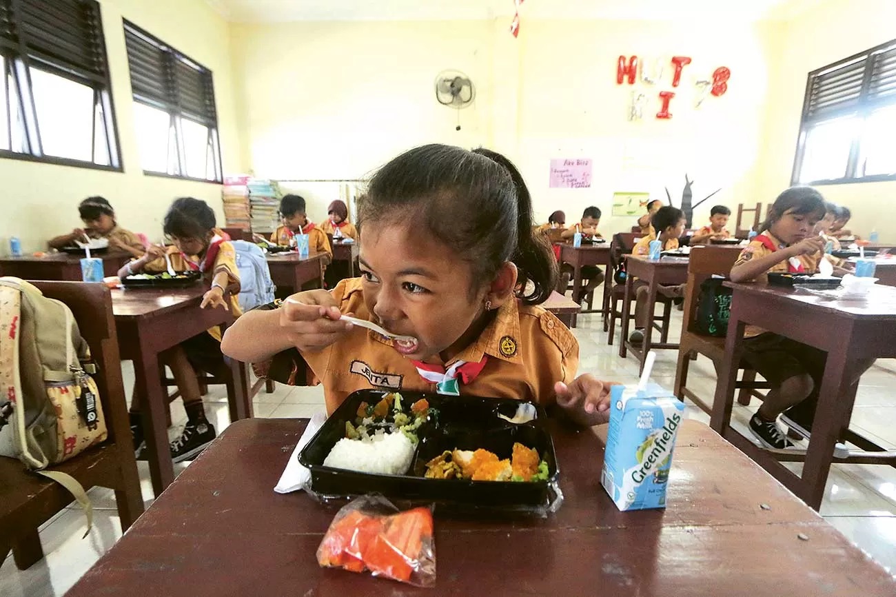 MAKAN BERGIZI GRATIS: Sejumlah murid SD menikmati makan bergizi gratis, merupakan salah satu program andalan Prabowo-Gibran. ISTIMEWA/JAWAPOS