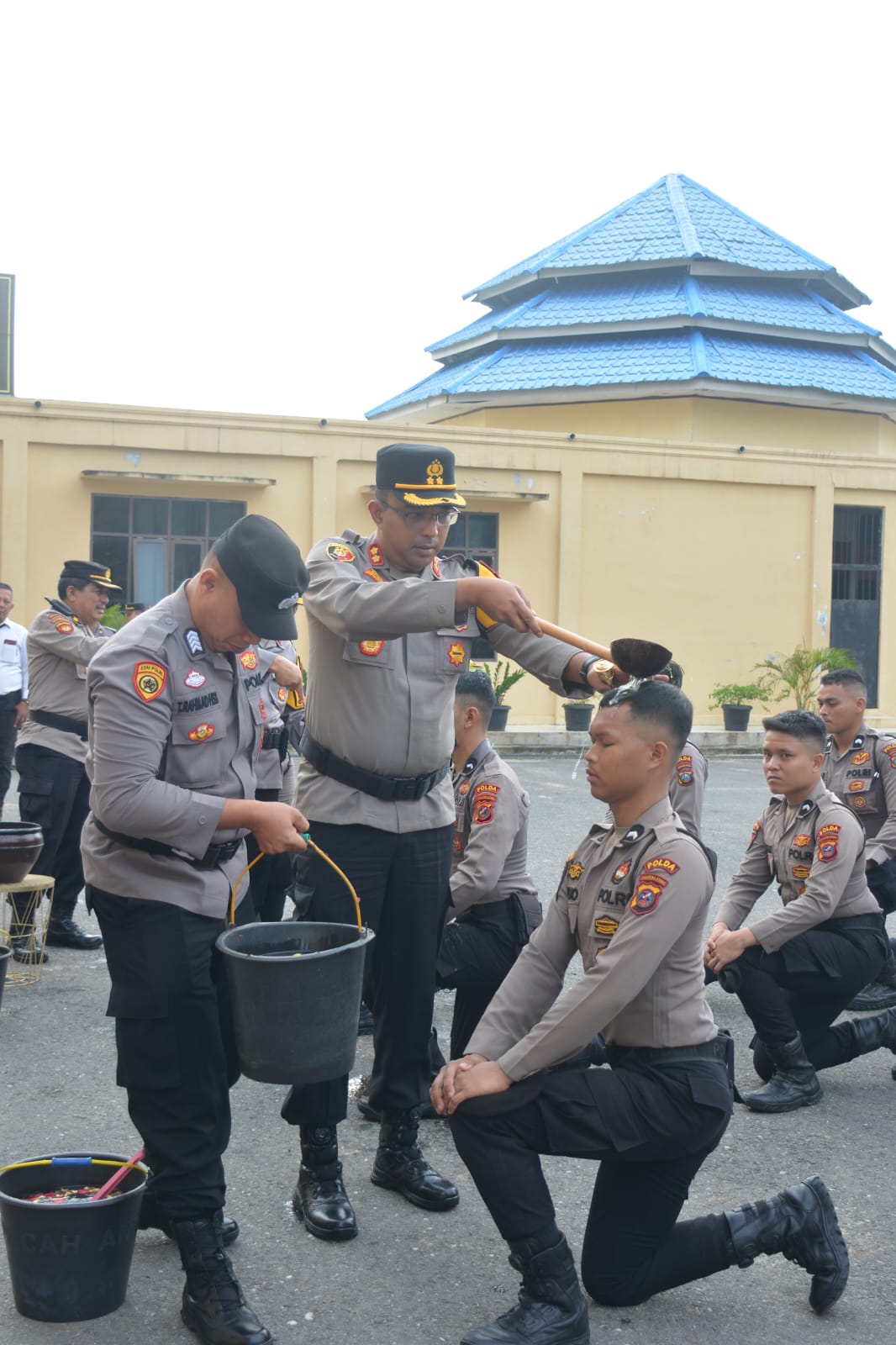 MANDIKAN: Kapolres Labusel AKBP Arfin Fachreza memandikan bunga kembang kepada  personel yang baru bertugas di Polres Labusel. KHAIRUDDIN/SUMUT POS
