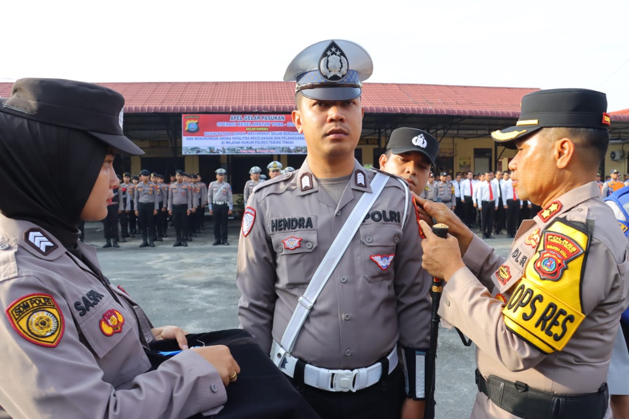 SEMATKAN: Kapolres Tebingtinggi AKBP Simon Paulus Sinulingga menyematkan pita kepada personel kepolisian Polres Tebingtinggi tanda dimulainya Operasi Keselamatan Toba tahun 2025. SOPIAN/SUMUT&nbsp;POS