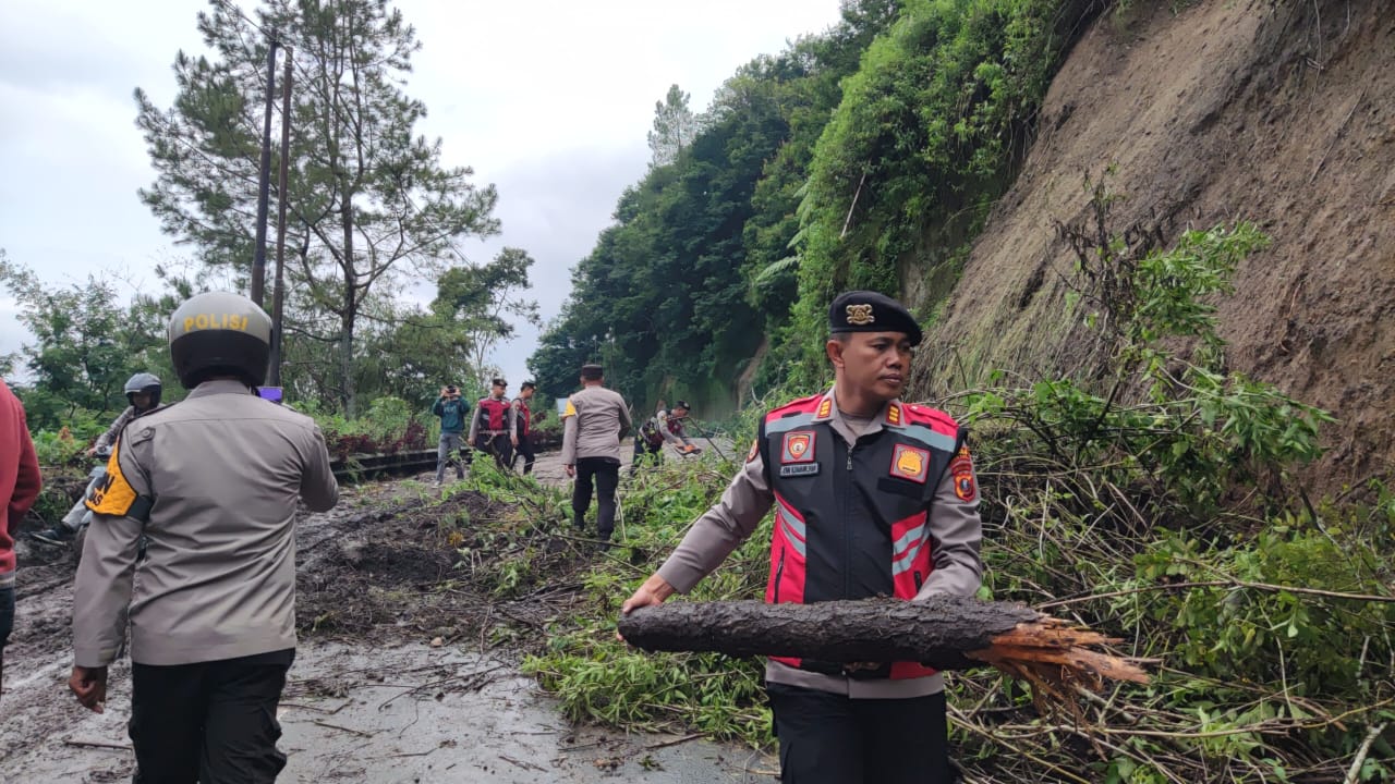 BERSIHKAN: Personel Polres Tanah Karo membersihkan tanah longsor yang menutupi badan jalan, di kawasan Barus Jahe, Kabupaten Karo, pada Minggu (16/2). Sumut Pos/Dokumen&nbsp;Pribadi