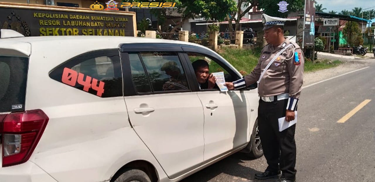 BAGIKAN: Personel Satlantas Polres Labusel membagikan brosur kepada pengendara  pada saat sosialisasi Operasi Keselamatan Toba 2025, Rabu (19/2/2025). KHAIRUDDIN/SUMUT&nbsp;POS