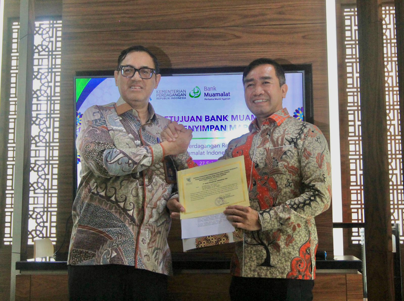 SURAT: Kepala Bappebti Tirta Karma Senjaya (kiri) menyerahkan secara simbolis surat persetujuan kepada Direktur Bank Muamalat, Karno di Jakarta, Kamis (27/2/2025). (Dok: Bank Muamalat)