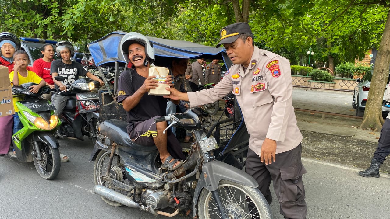 BAGIKAN: Waka Polres Tebingtinggi Kompol Ady Santri Wijaya bersama personel kepolisian lainnya membagikan takjil geratis kepada masyarakat di Jalan DI Panjaitan Kota Tebingtinggi. ISTIMEWA/SUMUT&nbsp;POS