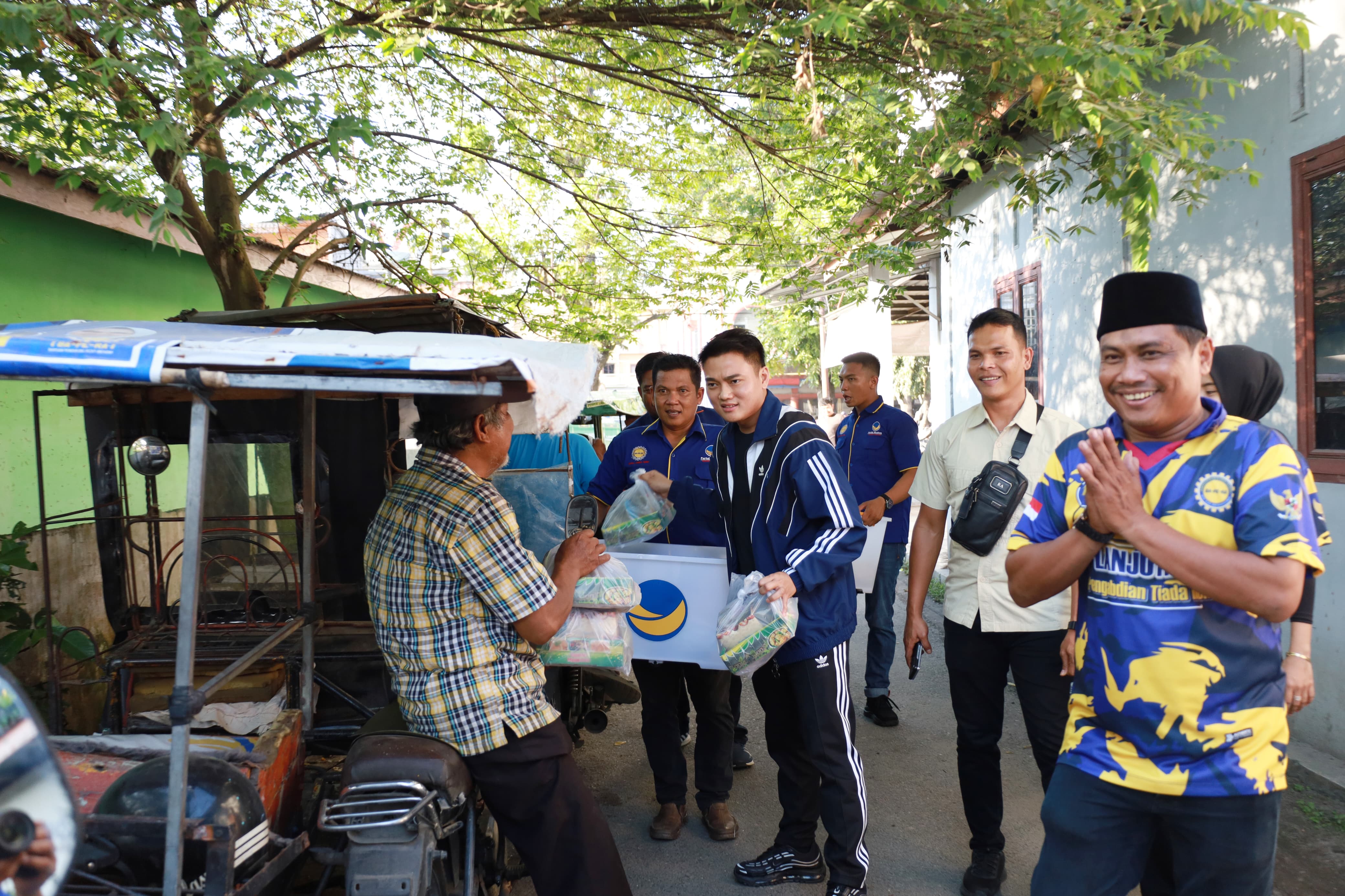 BERBAGI: Ricky Anthony saat berbagi makanan untuk berbuka puasa kepada abang becak di Stabat. FOTO: Istimewa/Sumut Pos