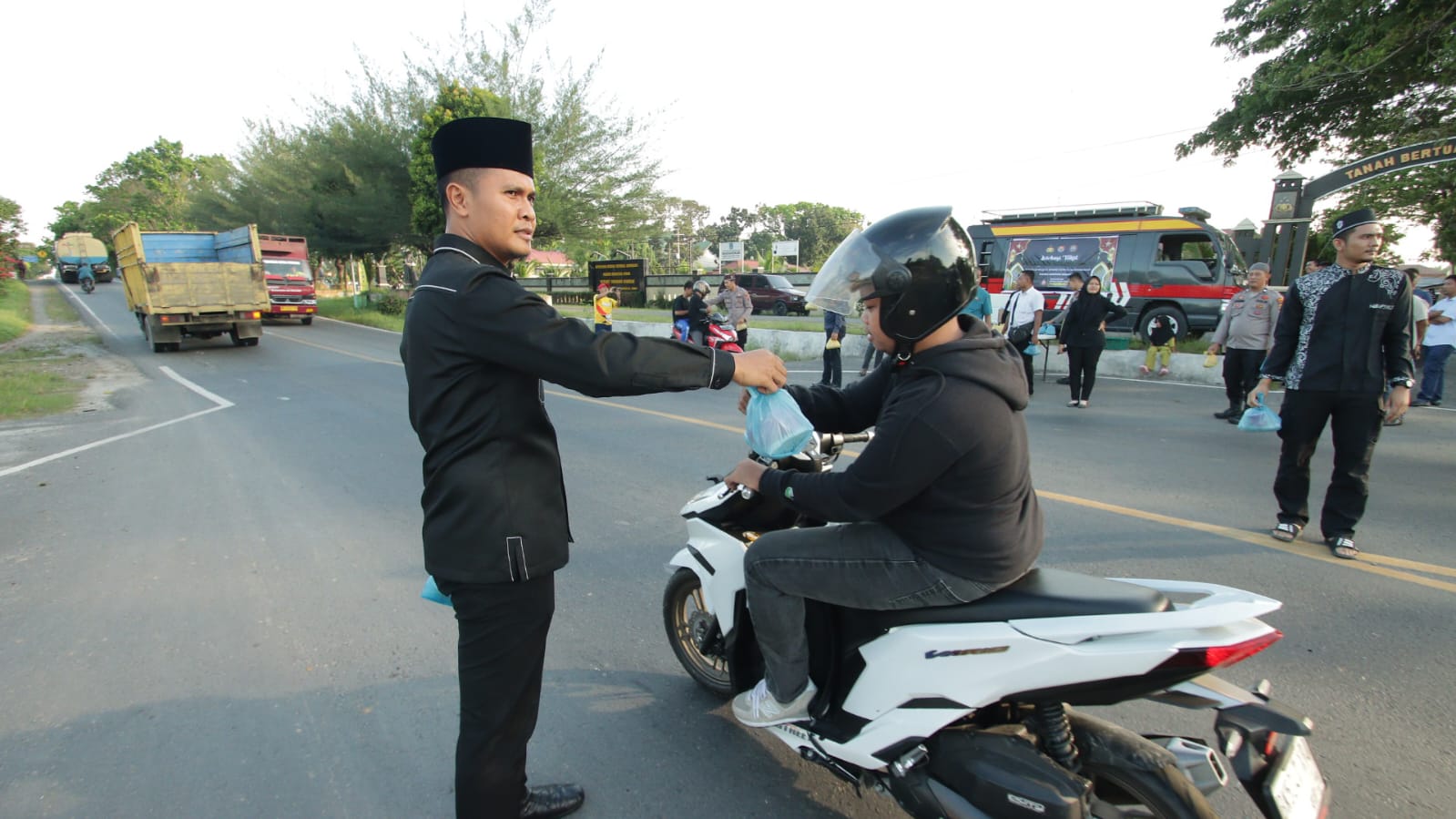 BAGIKAN: Ps Kasi Humas Polres Sergai Iptu Zulfan Ahmadi, SH, MH saat bagikan takjil kepada pengguna jalan  (15/3/2025). (FADLY/SUMUT POS)