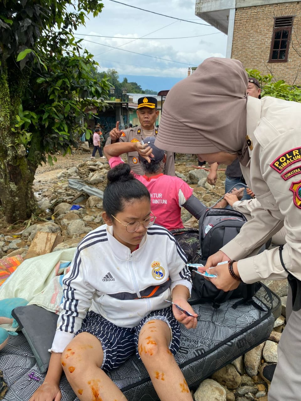 PERIKSA: Tim Dokkes Polres Simalungun memberikan pelayanan kesehatan kepada warga terdampak banjir bandar di Parapat, (PRA EVASI/SUMUT POS)