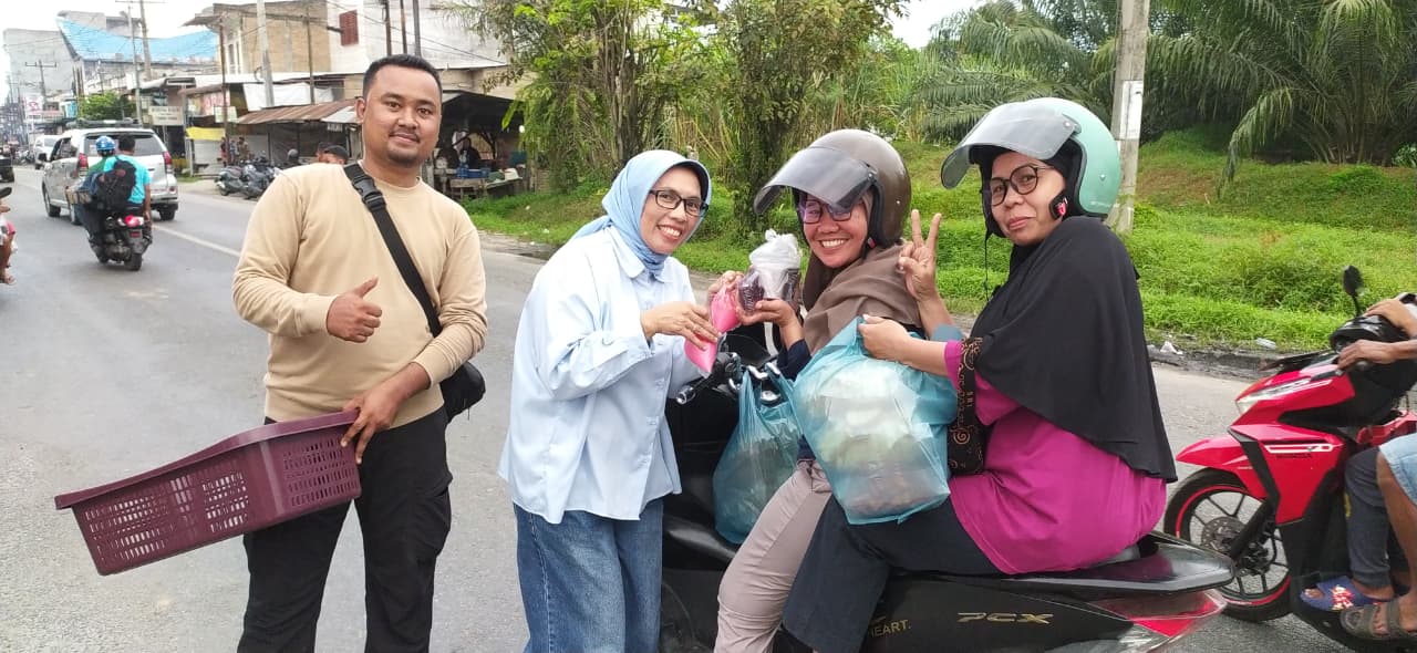 BERBAGI: Ketua FAMMILI Helmi Syam S.Kom, anggota dari KSJ Floria Yapanica Simanjuntak membagikan takjil kepada pengendara, Pedagang UMKM dan Para Tukang Ojek,  Foto :Liberti  Haloho/Sumut Pos