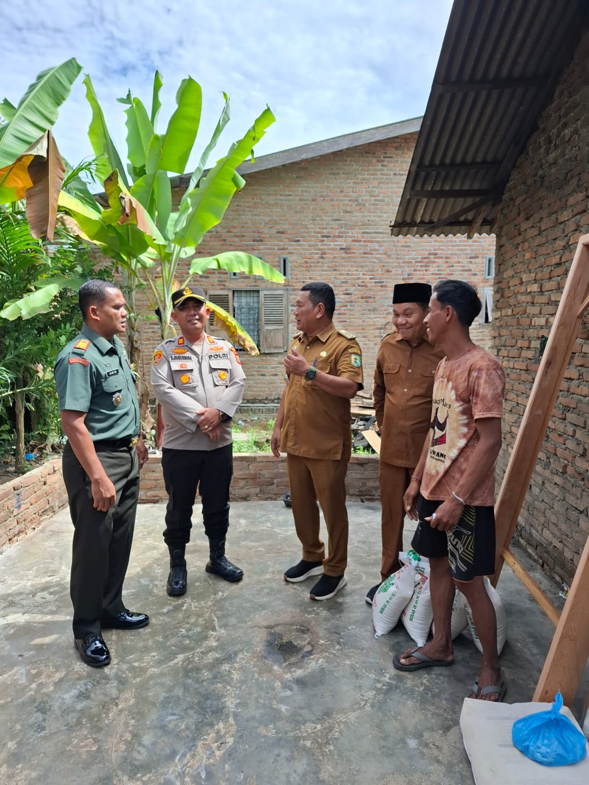 BANTUAN: Kapolsek Perbaungan AKP S.Gurunga bersama TNI dan pemerintah daerah menyalurkan bantuan sosial kepada warga yang terdampak musibah. (FADLY/SUMUTPOS)
