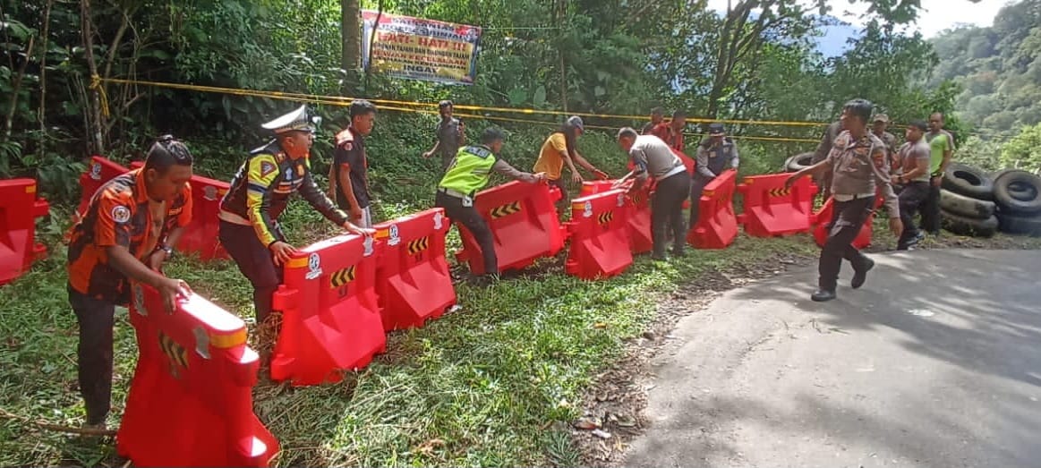 PEMBATAS Satlantas Polres Binjai dan masyarakat pasang pembatas jalan serta warer barrier di Jalan Lintas Langkat-Karo.  Satlantas Polres Binjai/Sumut Pos