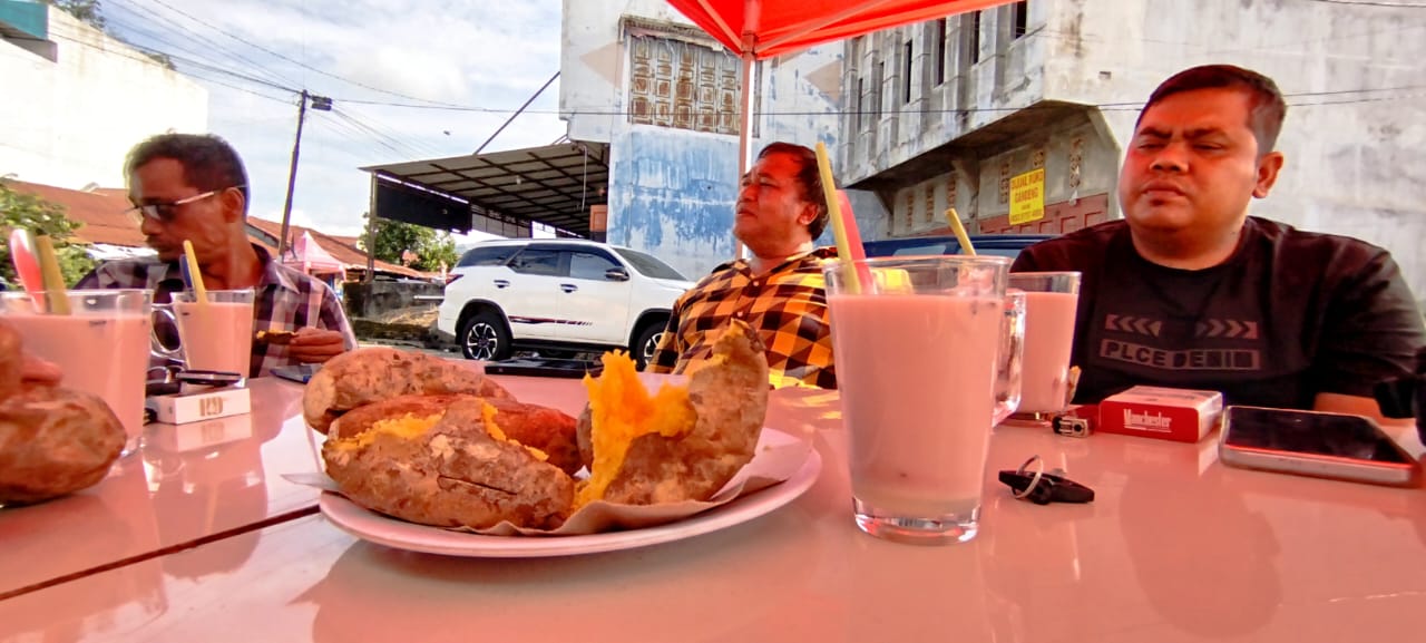 MAKAN: Warga saat menikmati makanan tradisional ubi cileumbu dan teh booster di Wong Tulus, Rantauprapat.