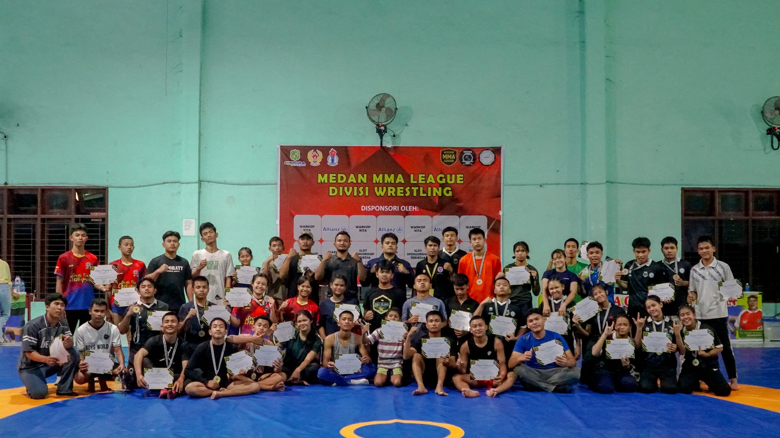 BERSAMA: CEO Medan MMA League, Aldo Yusuf Satria Simangunsong SPd bersama peserta Divisi Wrestling Medan MMA League di GOR Advent, Jalan Air Besih, Jumat (25/4/2025). (dok pribadi)