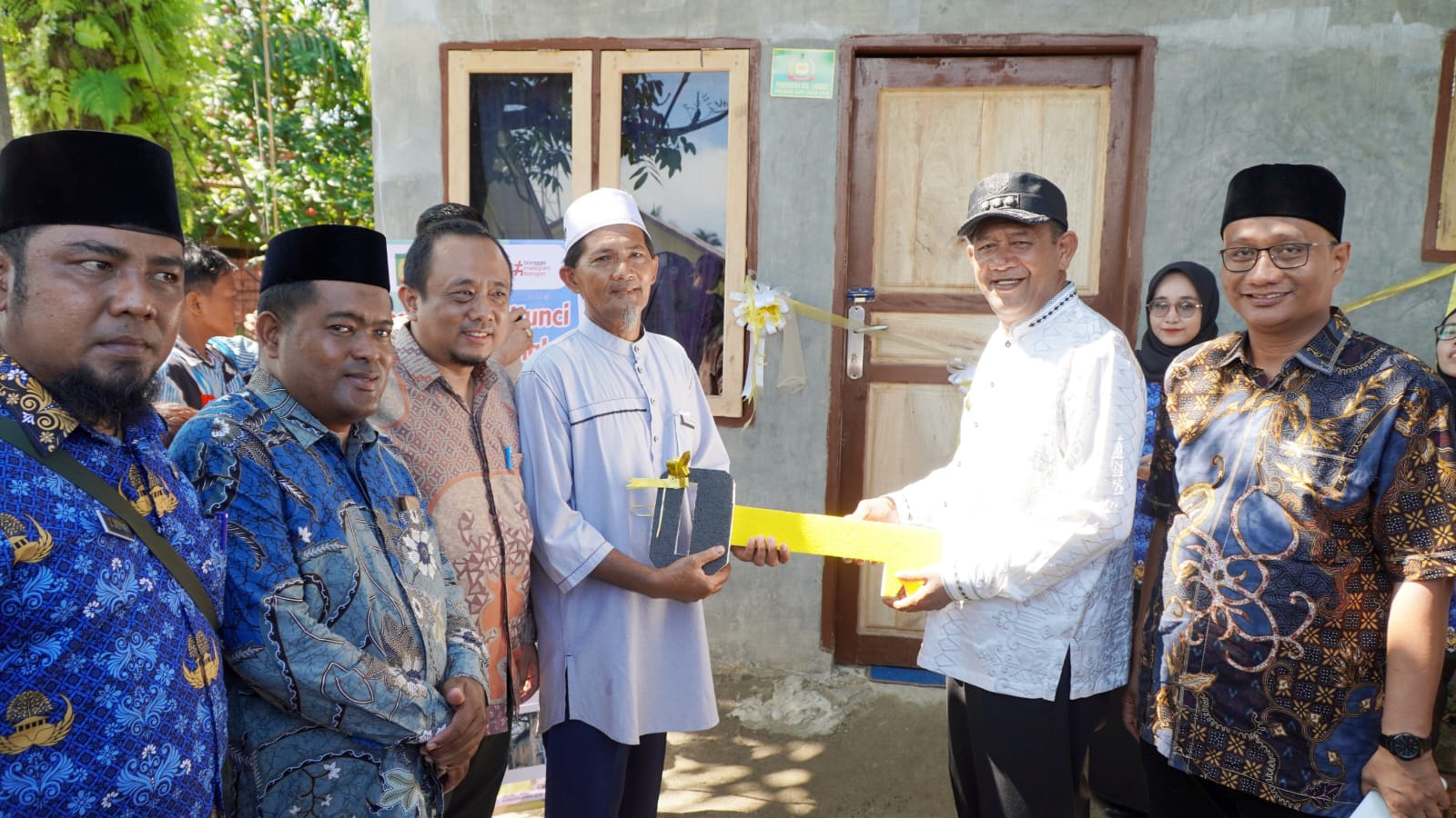 BEDAH RUMAH: Bupati Langkat, Syah Afandin saat menyerahkan secara simbolis kunci bedah rumah kepada Abdullah di Desa Tapak Kuda, Tanjungpura.Diskominfo Langkat/Sumut Pos