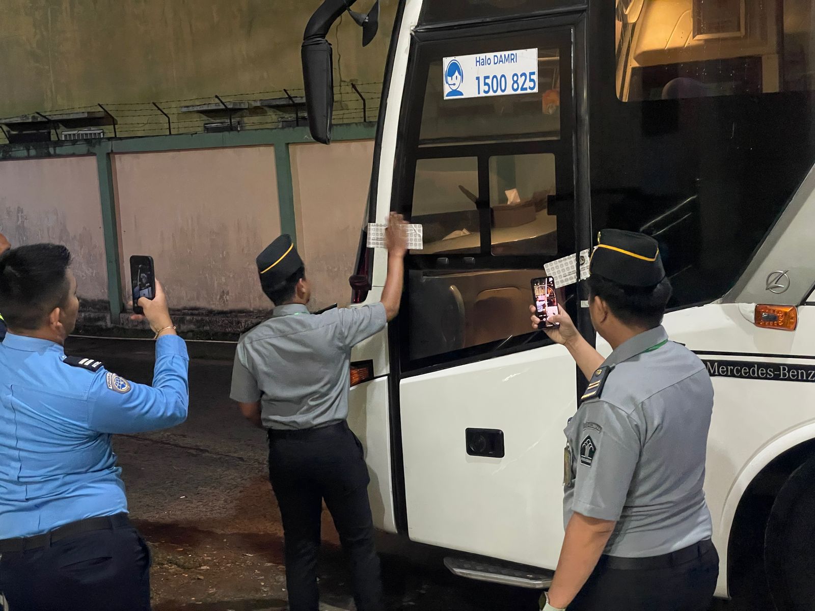 STIKER: Petugas Imigrasi Medan saat menempelkan stiker di bus jamaah calon haji Medan di Asrama Haji. (Dok: Imigrasi Medan)