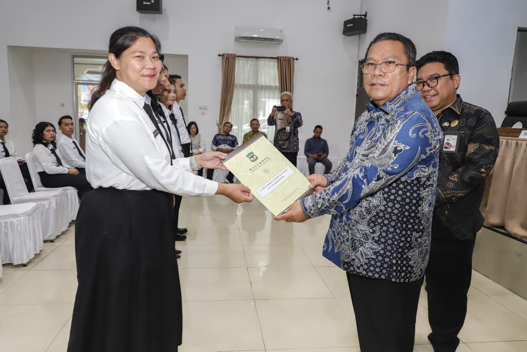 TERIMA: Senyum salah seorang CPNS saat menerima SK dari BKN yang diserahkan oleh Wali Kota Siantar, Wesly Silalahi. PRA EVASI/SUMUT POS