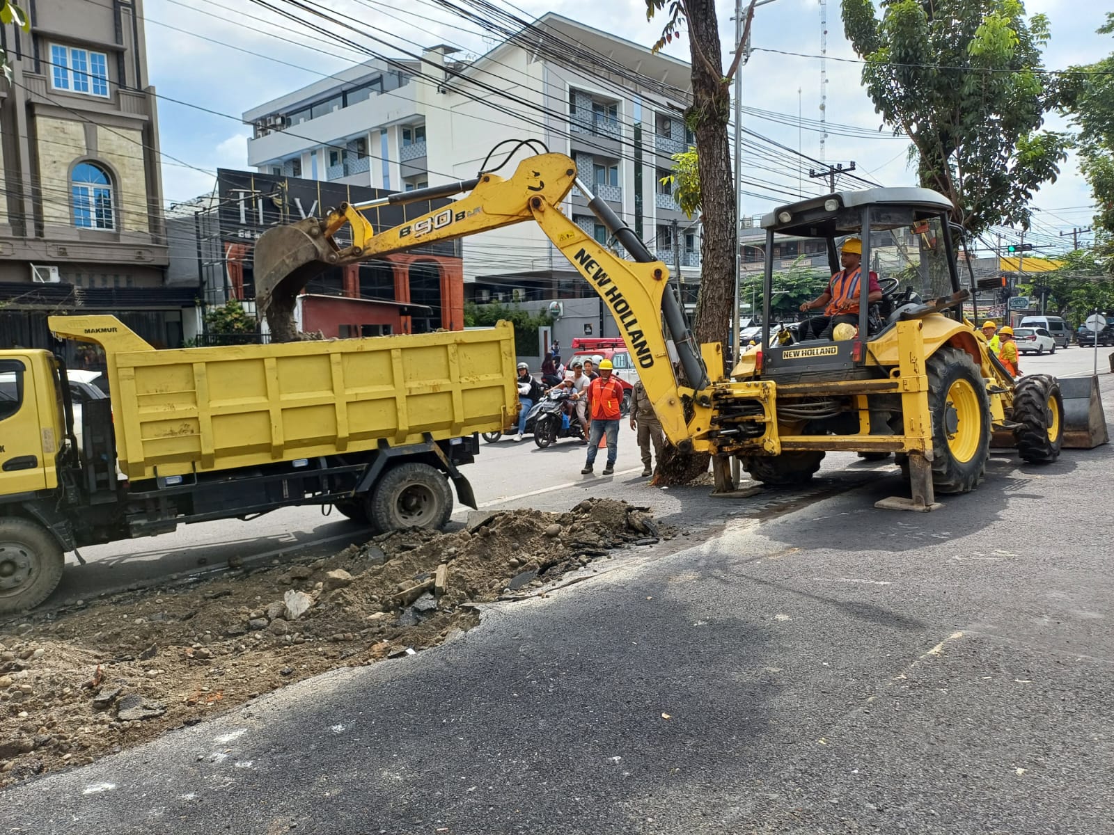 BONGKAR: Alat berat Dinas SDABMBK Kota Medan membongkar aspal yang dibangun Dara Kupi di atas trotoar, Senin (19/5/2025). Foto : Markus Pasaribu/Sumut Pos
