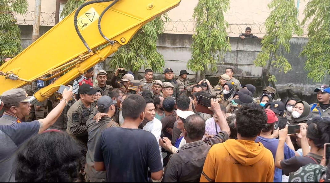 PROTES: Warga Jalan Kolam, Desa Medan Estate, Kecamatan Percut Seituan, Kabupaten Deliserdang saat memprotes Satpol PP yang ingin merobohkan rumah rumah mereka. Sumut Pos/Dewi Syahruni Lubis