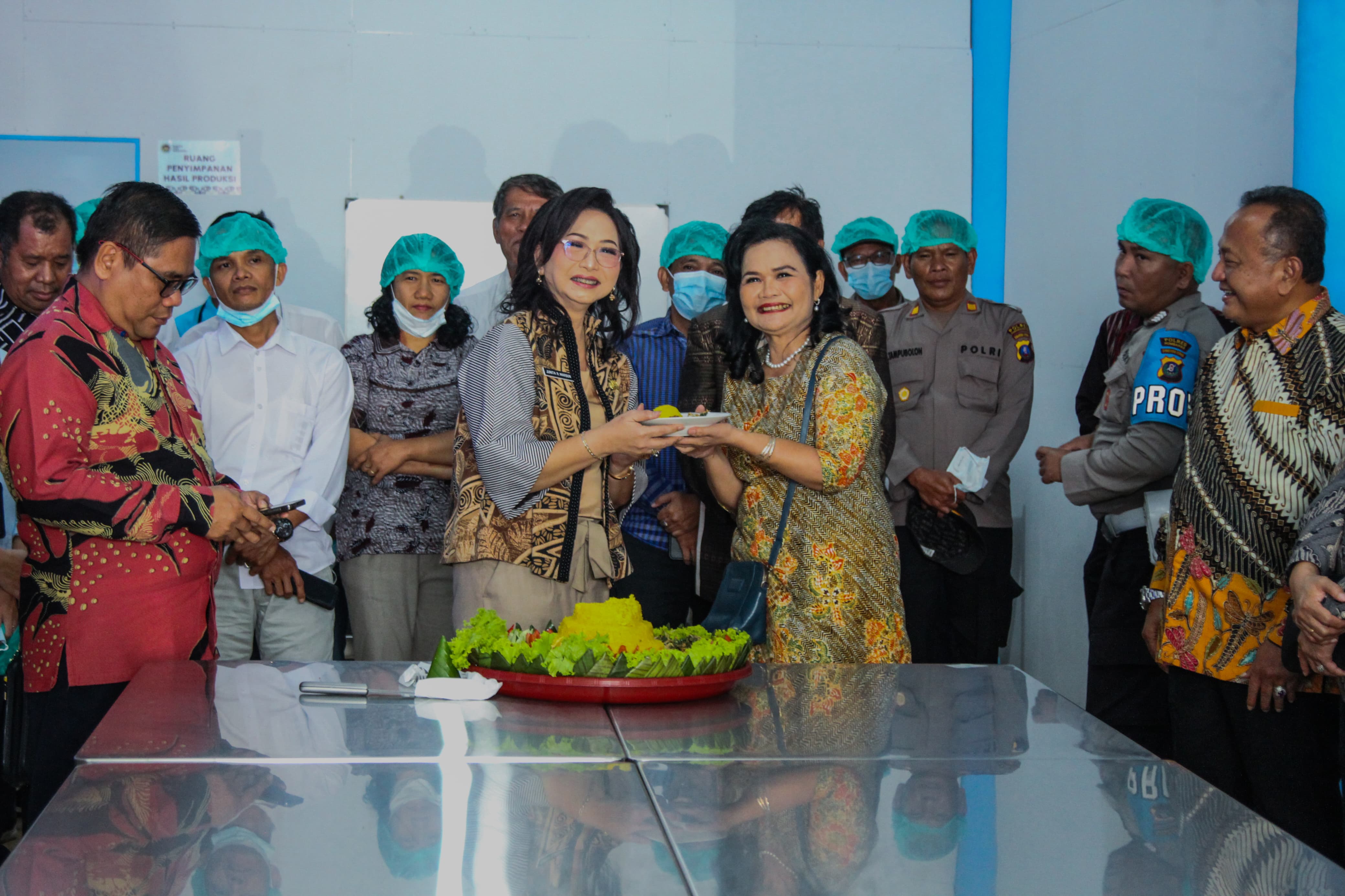 RESMI: Wakil Bupati Humbahas, Junita Rebekka Marbun memberikan potongan nasi tumpeng kepada Pembina Yayasan Holong Ondolan Indonesia Emas, Astilda Sinabutar saat peresmian dapur MBG.
