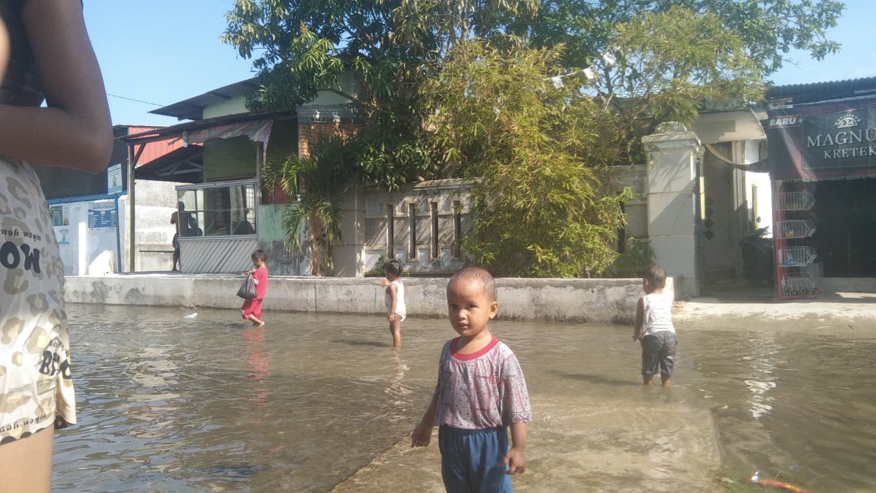 BERMAIN: Sejumlah anak-anak bermain air di lingkungan mereka yang tergenang air banjir rob, Jumat (30/5/2025). FOTO: IKSAN/SUMUT POS