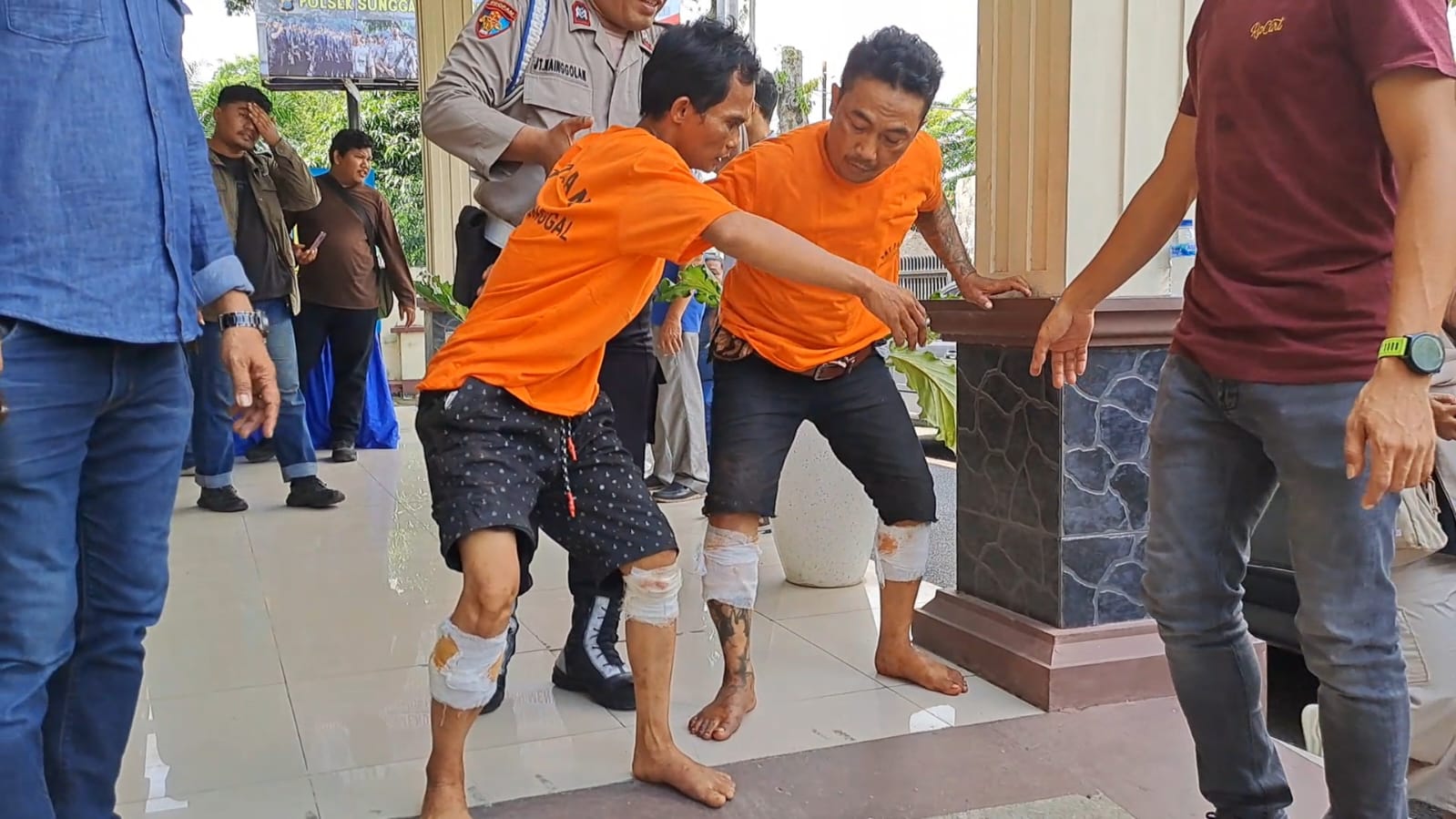 DIGIRING: Kedua tersangka residivis kasus bongkar rumah digiring petugas dengan kaki ditembak, Senin (2/6). AGUSMAN/SUMUT POS