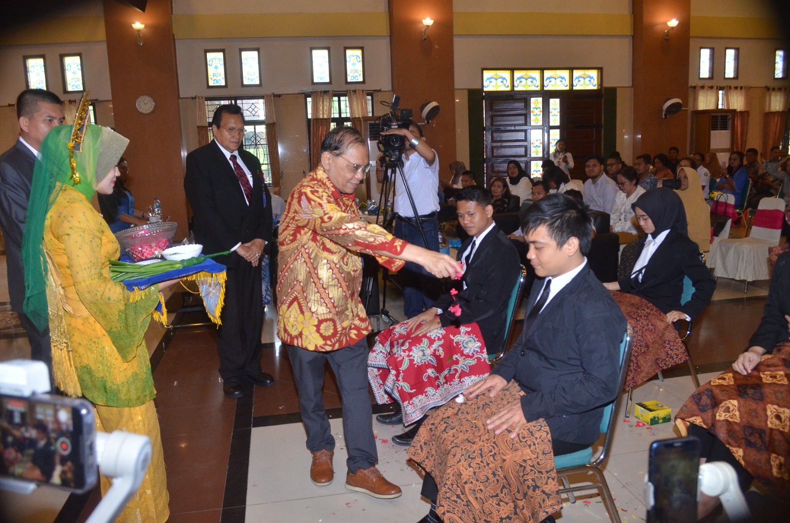 TEPUNG TAWAR: Kepala LLDIKTI 1 Sumut, Saiful Anwar Matondang tepung tawar lulusan di Delitua yang akan berangkat kerja ke luar negeri. (Dok: istinewa/Sumut Pos)