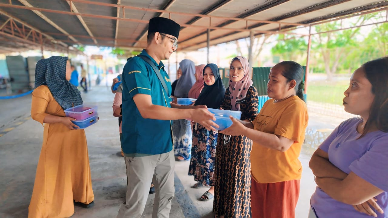 BAGIKAN: Salah seorang Perwakilan RSI saat bagikan daging kurban kepada warga sekitar. (FADLY/SUMUT POS)