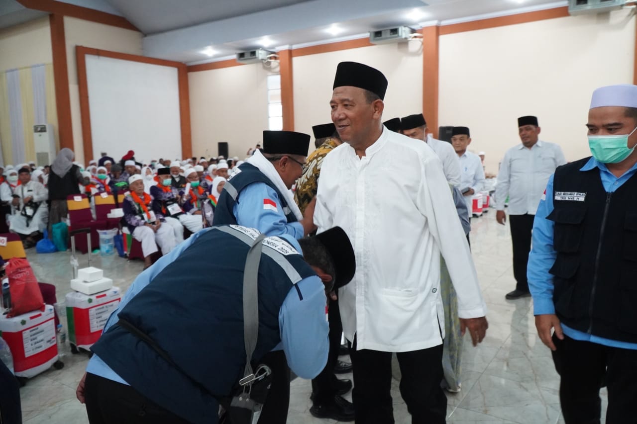 SALAMI: Bupati Langkat, Syah Afandin saat menyalami jamaah haji asal Langkat yang baru tiba di tanah air. Diskominfo Langkat/Sumut Pos