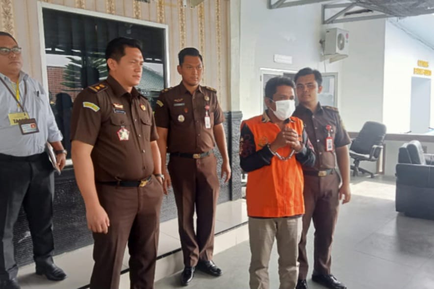 DITAHAN: Mantan Kades Rasau, Ilham Harahap, mengenakan rompi orange dan digari saat ditahan Kejari Labusel. foto: Khairuddin/Sumut Pos