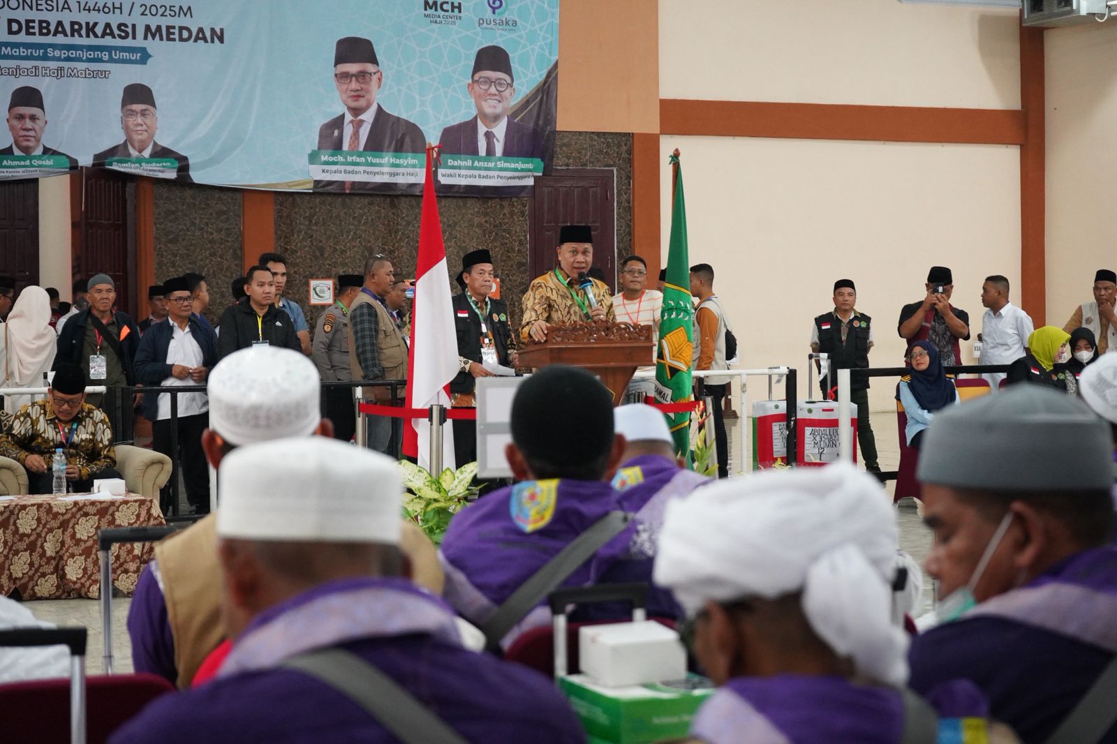SAMBUTAN: Ketua Petugas Penyelenggara Ibadah Haji (PPIH) Debarkasi Medan Tahun 1446 H / 2025 M, Ahmad Qosbi saat memberikan sambutan pemulangan Kloter 12 di Asrama Haji Medan.