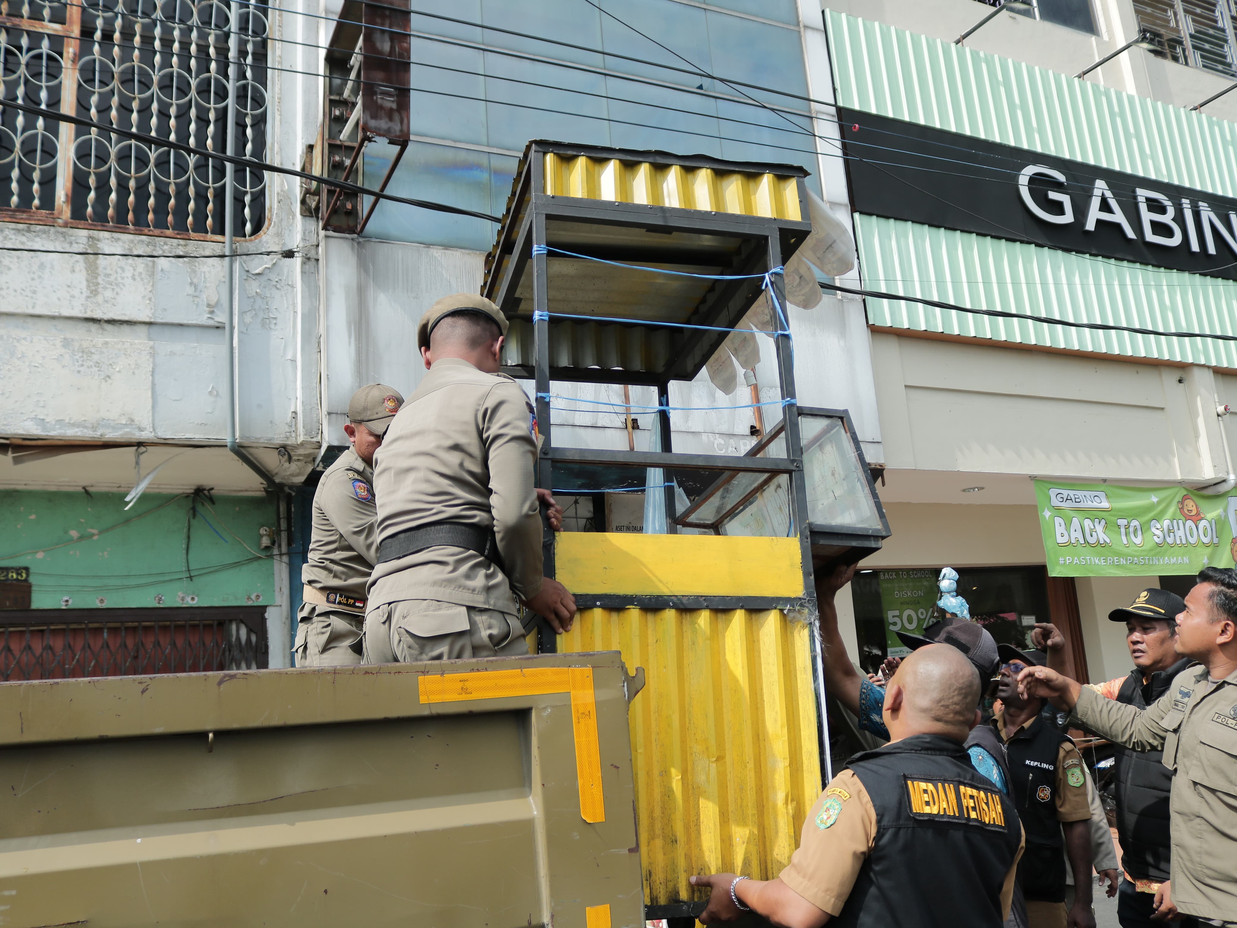 ANGKUT: Petugas tim gabungan mengangkut gerobak pedagang yang berjualan di trotoar sepanjang Jalan gatot Subroto Medan.