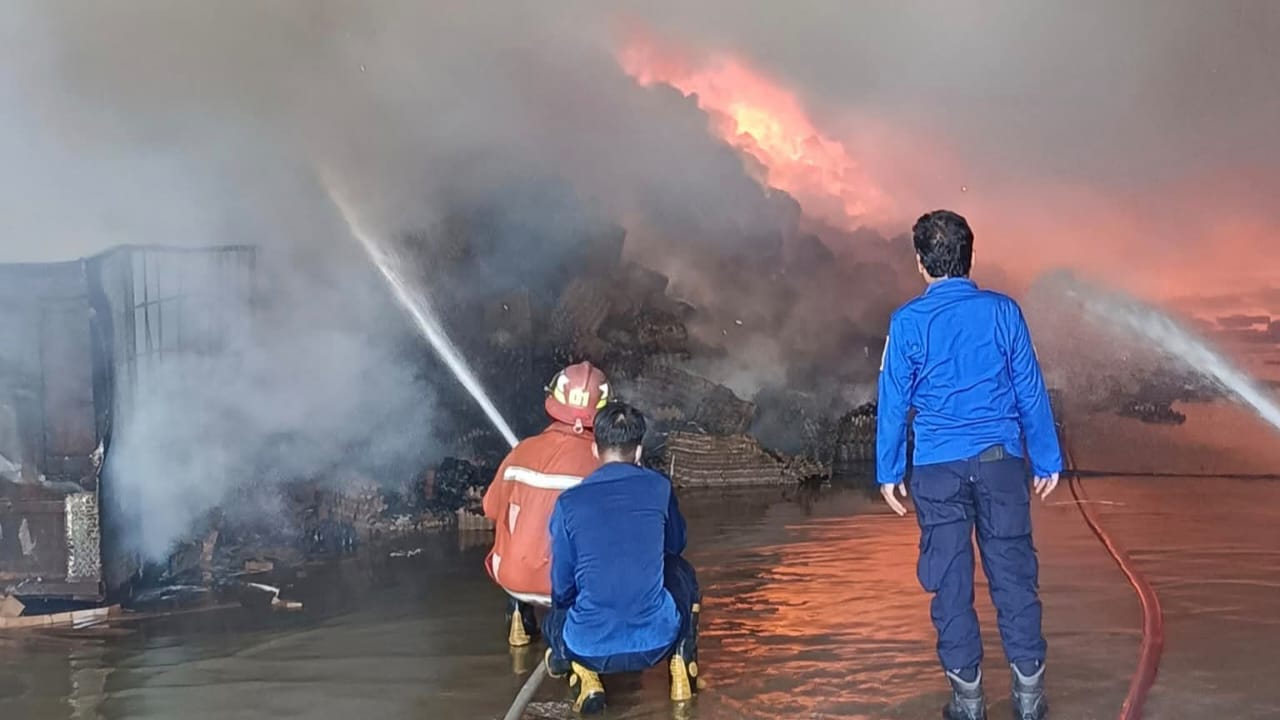 KEBAKARAN: Petugas pemadam kebakaran menjinakkan si jago merah di pabrik produksi sarang telur.