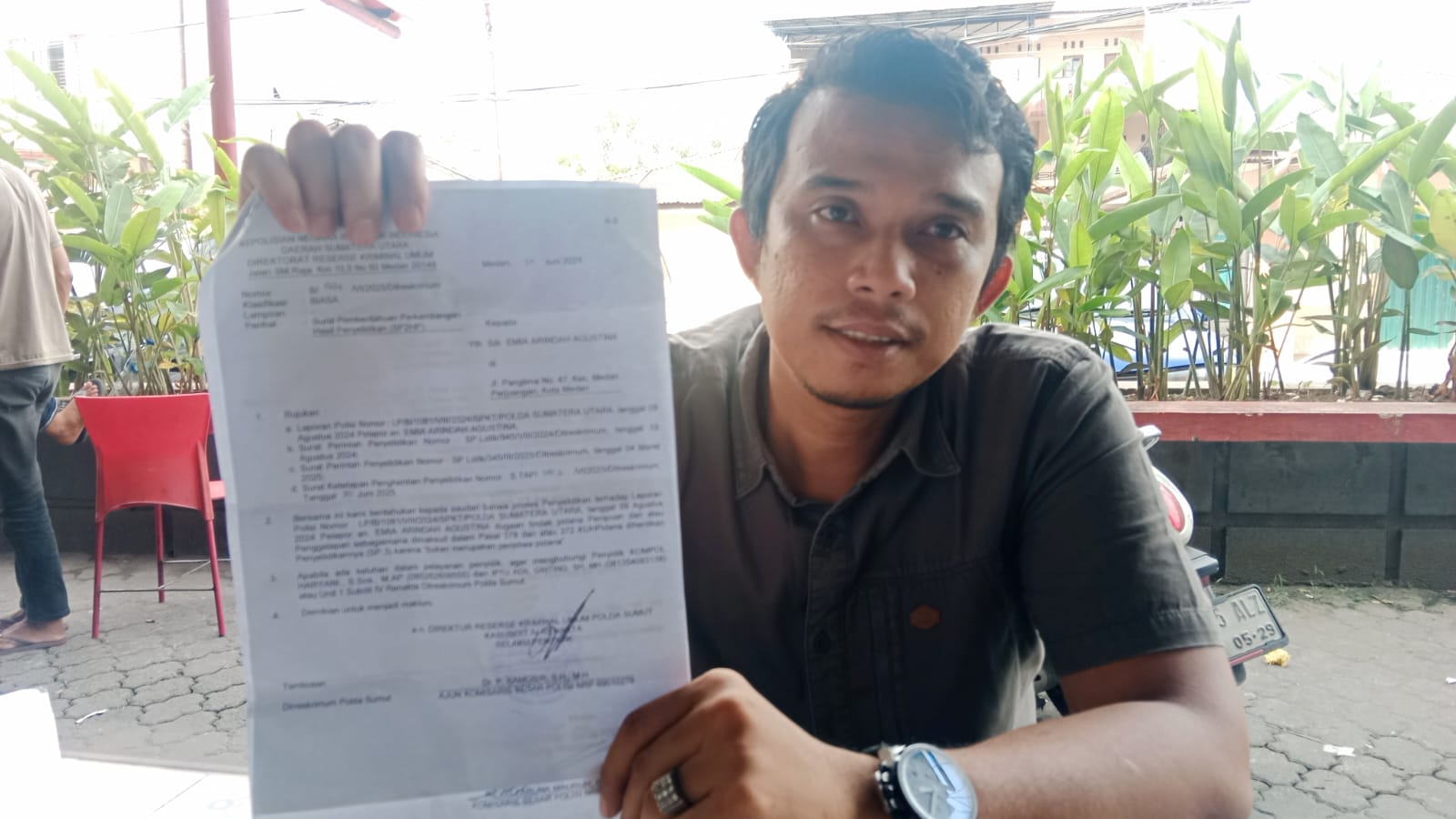 SP3: Robby Marshel Sinaga selaku kuasa hukum korban kasus penipuan, menunjukkan surat SP3 dari Polda Sumut, Jumat (11/7).
