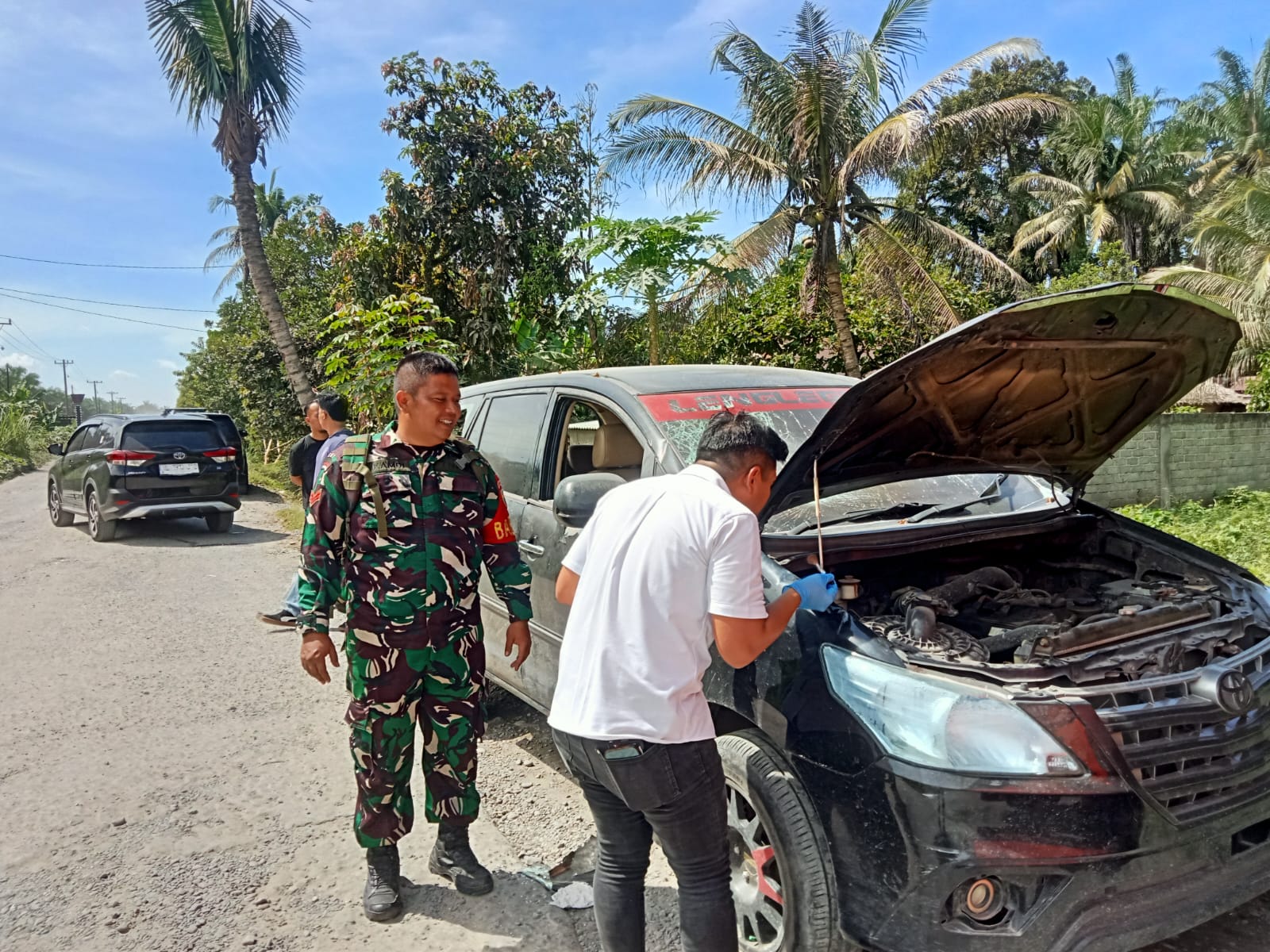 PERIKSA: Petugas kepolisian melakukan pemeriksaan terhadap mobil yang diduga diserang lebih dulu hingga akhirnya bentrokan pecah di Selesai, Langkat