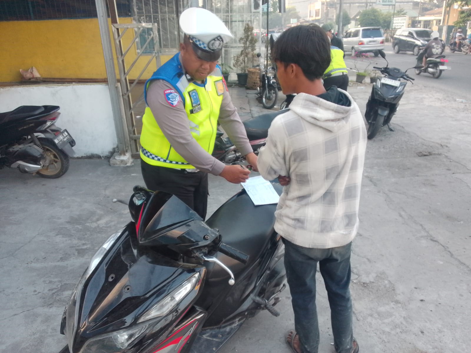 PENINDAKAN: Personel Satlantas Polres Labuhanbatu lakukan penindakan terhadap pengendara yang melanggar lalu lintas selama Operasi Patuh Toba 2025 (