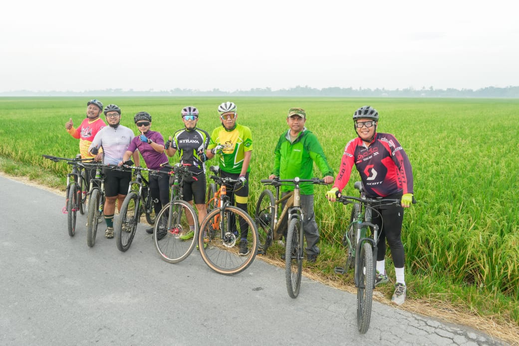 SEPEDA: Bupati Sergai Darma  Wijaya bersama Ketua KONI Usman Efendi Sitorus bersepeda sekaligus tinjau sawah dan temui Petani. (Dok: Fadli/Sumut Pos)