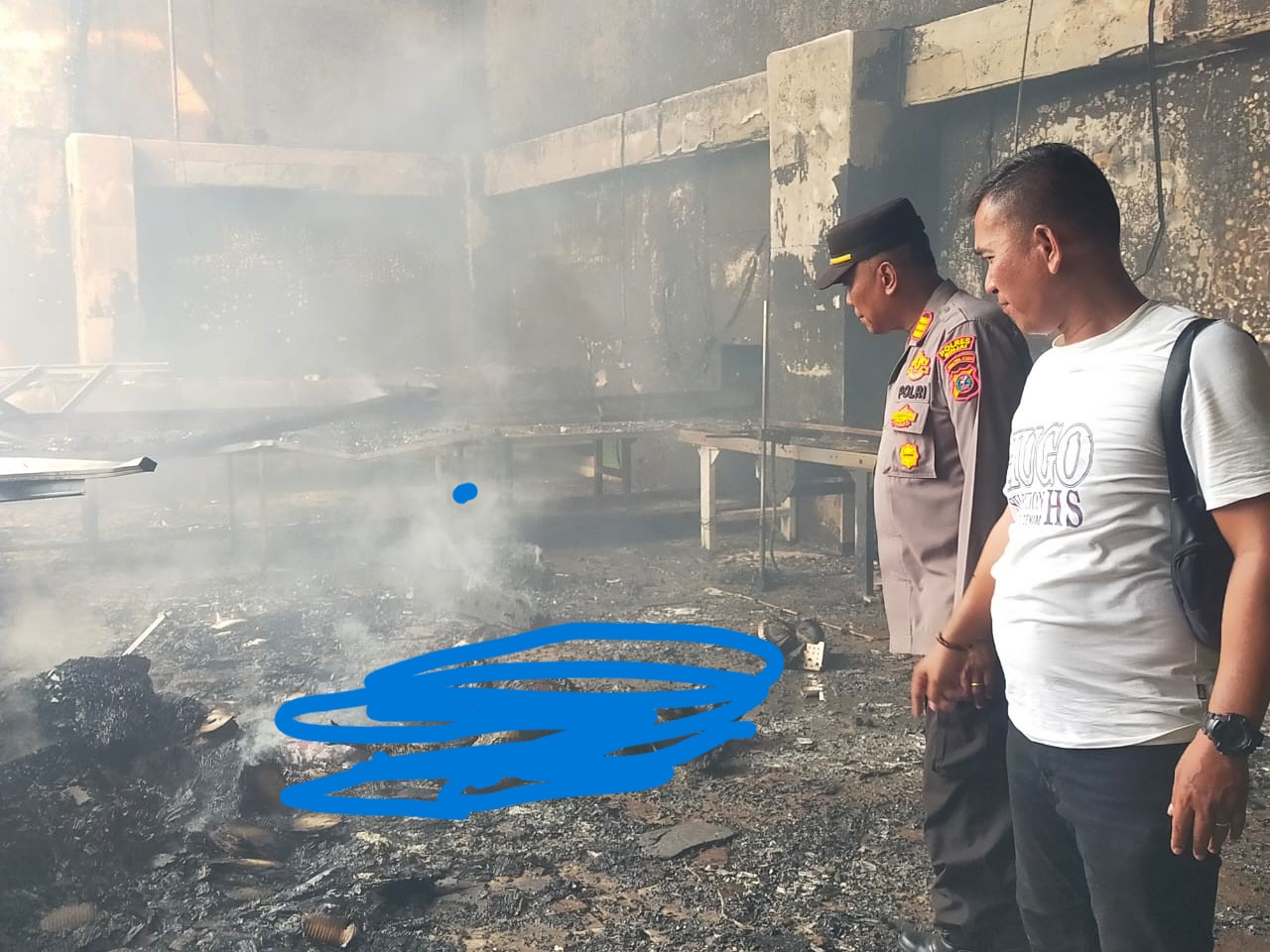 TERBAKAR: Petugas kepolisian saat melihat korban yang mengalami luka bakar di pabrik produksi mie instan.