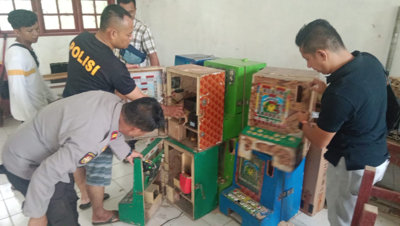 AMANKAN: Polsek Bahorok saat mengamankan mesin judi di dalam kelas pada sekolah tak aktif.