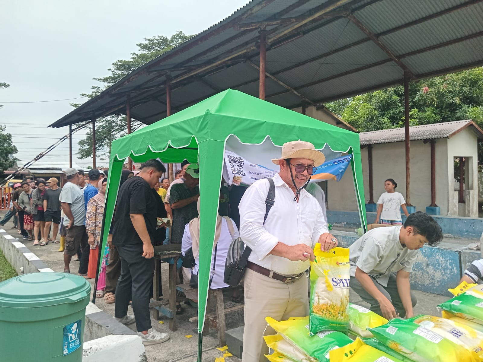 BERAS: Kordinator Gerakan Pangan Murah di Gudang Bulog Labuhan Deli, Rusli saat memotong pinggiran bungkus beras. (Dok: Juli Ramadhani Rambe/Sumut Pos)