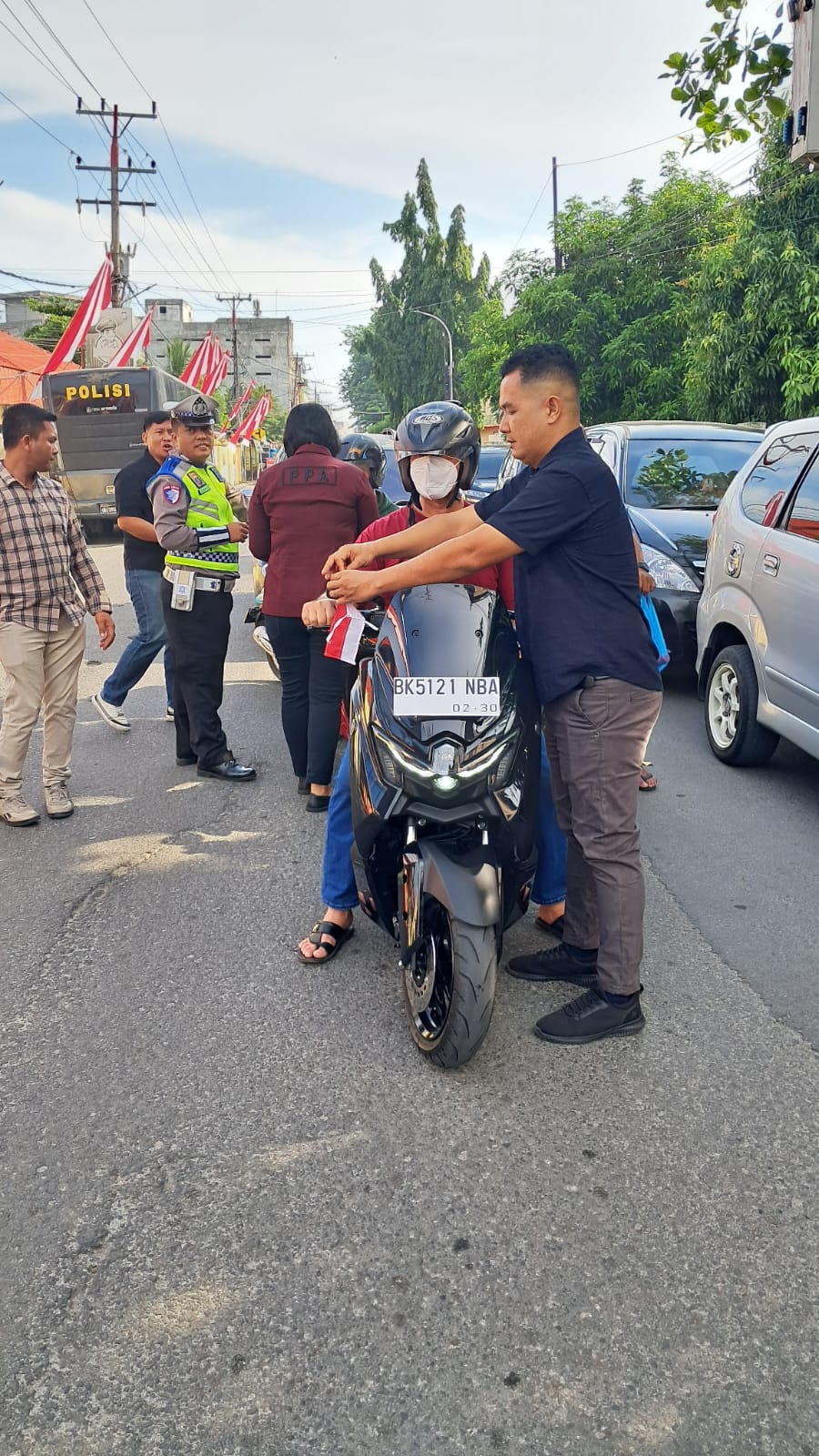 BAGIKAN: Jajaran Satreskrim Polres Tebingtinggi membagikan bendera merah putih kepada pengguna kendaraan sepeda motor di Jalan Pahlawan Kota Tebingtinggi.(Sopian/Sumut Pos)