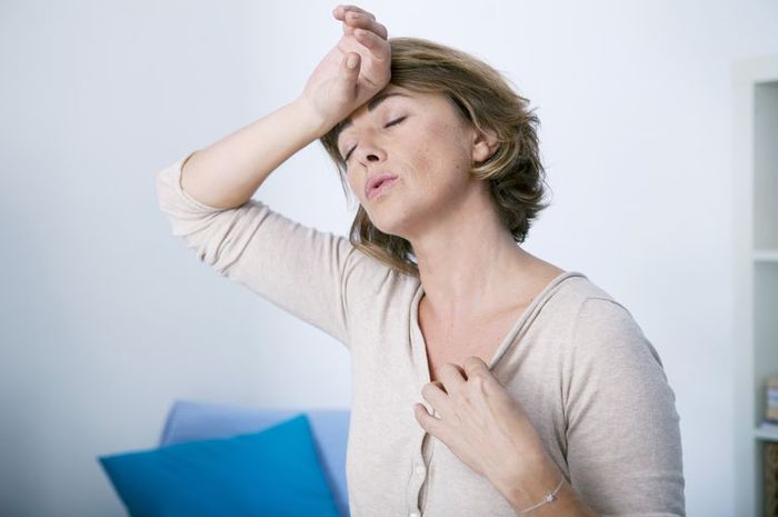 ilustrasi: Seorang wanita paruh baya sedang mengalami gejala menopause.