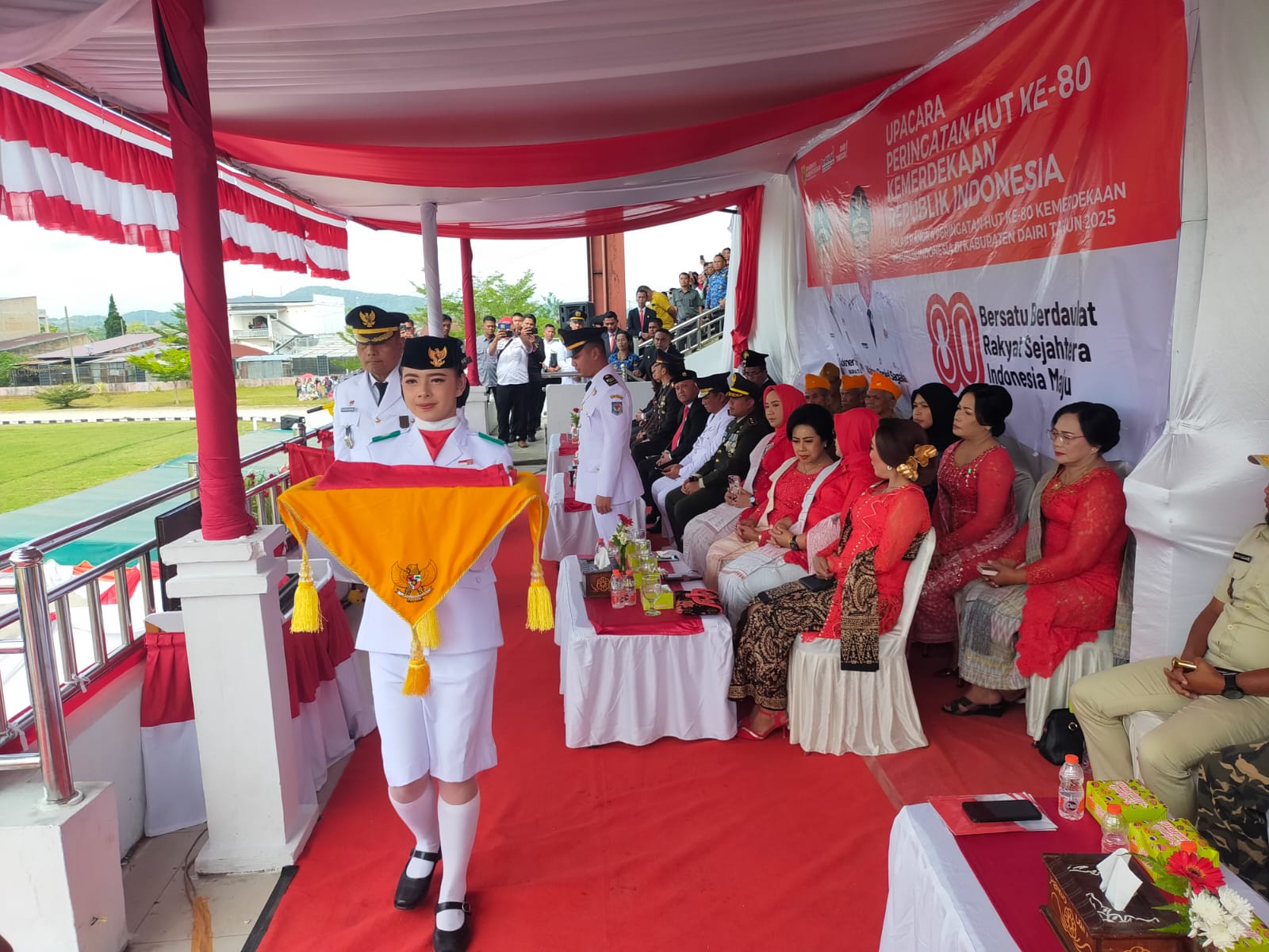 BENDERA. Tasia Onesi Gaberia Limbong membawa bendera untuk dikibarkan setelah diterima dari Bupati Dairi, Ir Vickner Sinaga.RUDY SITANGGANG/SUMUT POS.