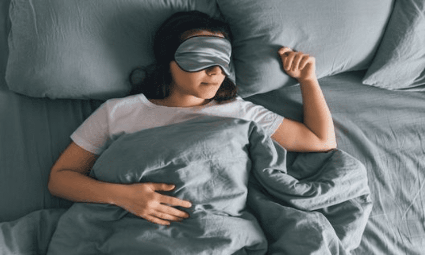 ilustrasi: Seorang wanita menutup matanya agar bisa tidur.